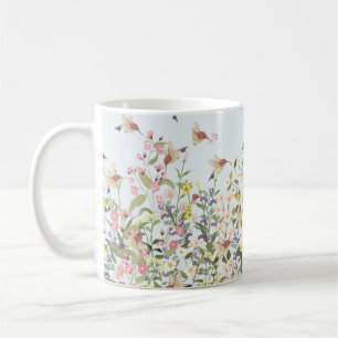 Fin hummingbird i sötad blommigt blomgarde kaffemugg