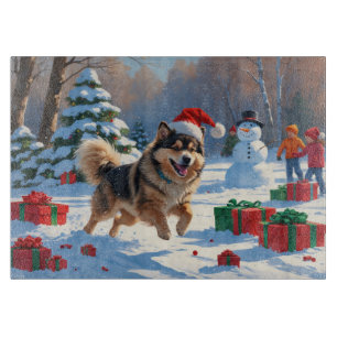 Finsk Lapphund springer i snö med julhatt