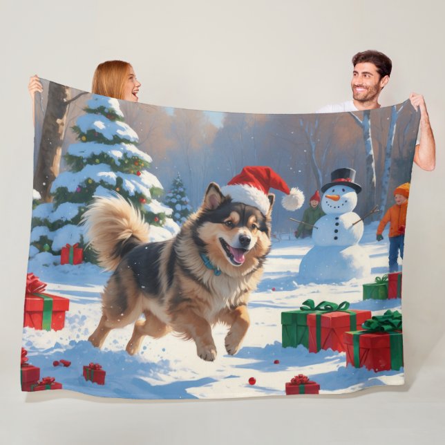 Finsk Lapphund springer i snö med julhatt Fleecefilt (På plats)