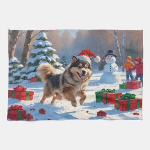Finsk Lapphund springer i snö med julhatt Kökshandduk