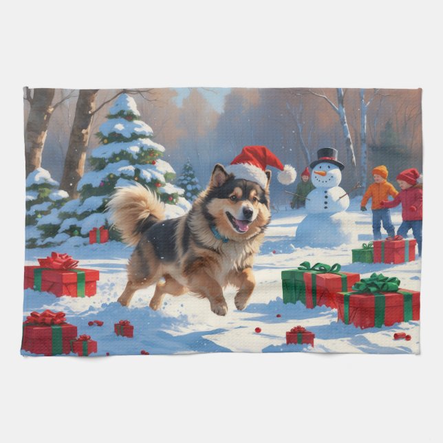 Finsk Lapphund springer i snö med julhatt Kökshandduk (Horisontell)
