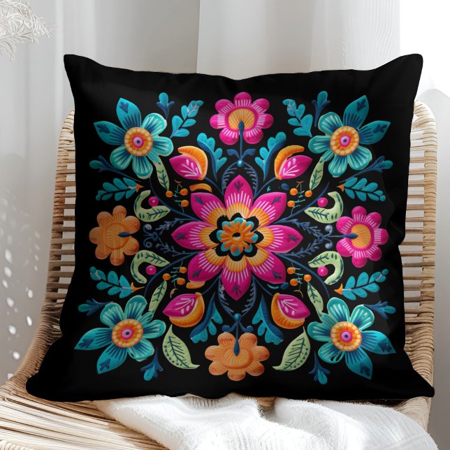 Fläckpatter för den mexikanska Blommigten Kudde (Colorful Mexican Floral Fiesta Patter Throw Pillow on a sunny rattan chair.)