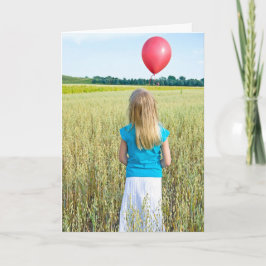 flicka i vete fält med röd ballong kort