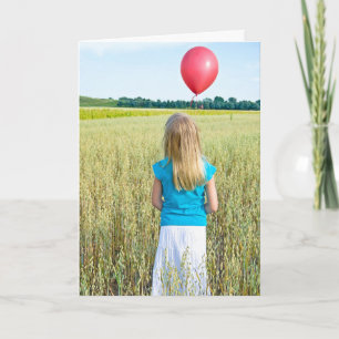 flicka i vete fält med röd ballong kort