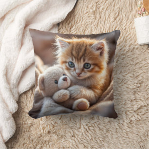 Fluffig röd kattunge som leker med en liten nalleb kudde