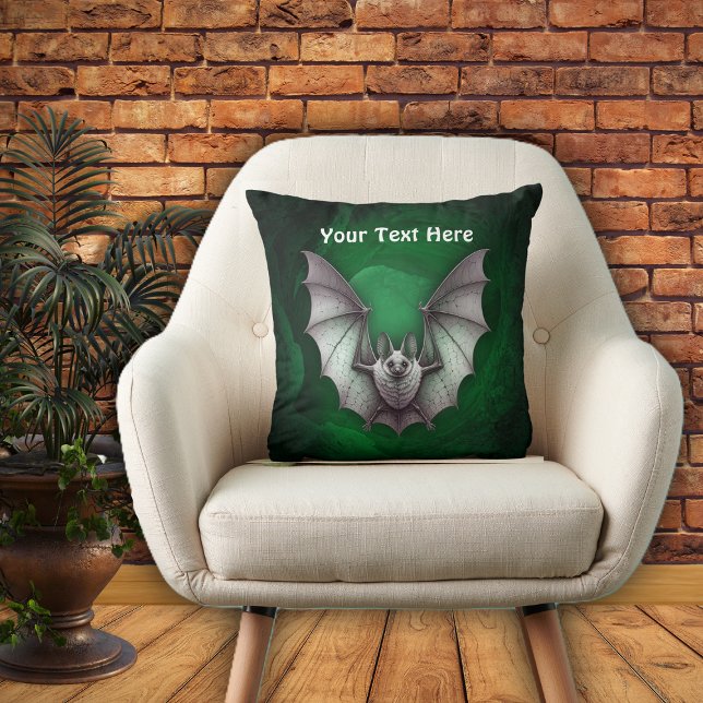 Flygande grå fladdermus kuslig grön glödande grott kudde (Grey bat flying from spooky glowing green cave with trees on Halloween throw pillow.)