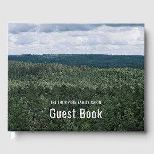 Flygfoto över nordisk skogsmiljö med familjestuga gästböcker