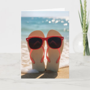 Födelsedagsglasögon på flip-flops i strandsand kort