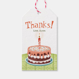 Födelsekakor vid rosa med ett ljus presentetikett