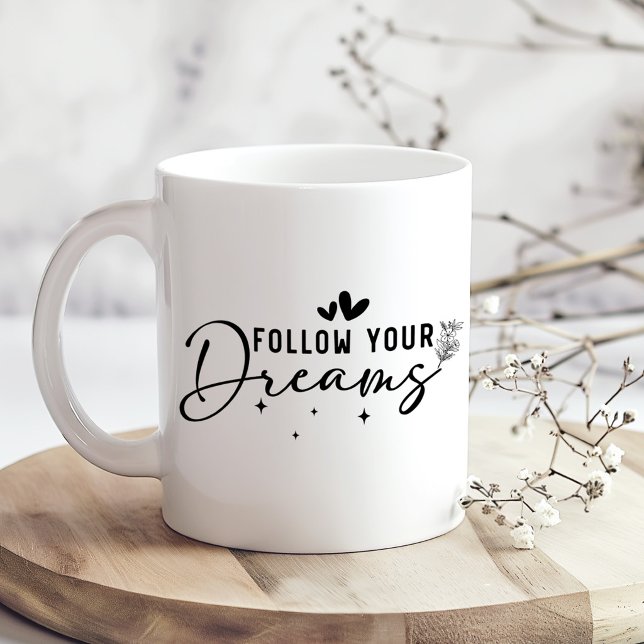 Följ Dina Drömmar Blommig Script Kaffe Mugg (Follow Your Dreams Floral Script Coffee Mug on a kitchen table with tiny dry flowers)