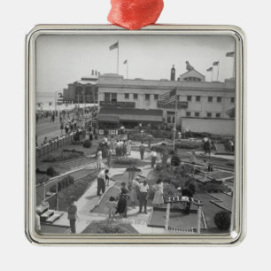 Folket som leker höjd mini- golf, beskådar B&W Julgransprydnad Metall