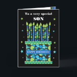För Son Birthday Cake med ljus och stjärnor Card Kort<br><div class="desc">Ett lysande födelsedagskort för din son, med många mönstrade ljus på en födelsedagskalas. Ord, "Till ett mycket speciellt SON", står överst på framsidan i en vit text på den svarta bakgrunden. Det finns ett blått band runt kakan med "GRATTIS PÅ FÖDELSEDAGEN!" också i vitt. Små blå, grönt och vita stjärnor...</div>