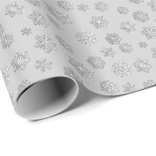Försilvra 3 D-snöflingor på en silvergrå Presentpapper