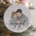 Första Julen - Engagerat fotoskript i Grått Julgransprydnad Keramik<br><div class="desc">Minneshögtidlighålla din förlovning med denna vackra,  moderna keepsaksprydnad. Grått-texten från kol lyder: "Vår första jul förlovad",  med ord försatt i fet handstil med blomning före och efter. Ersätt exempelbilden med ditt favoritfoto och lägg till namnen och året. Ett vitt övertoningsfilter hjälper till att göra så att texten visas.</div>