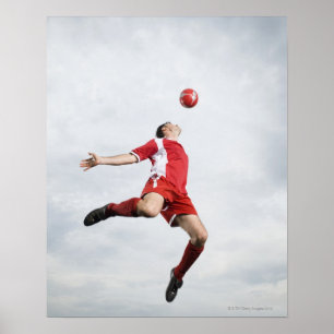 Fotbollspelare och fotbollboll i mitt--luft poster