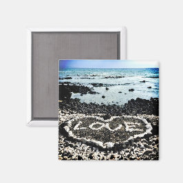 Foto på korallhjärta i kärlek vid svart sand magnet