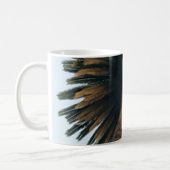 Fotografi över mask öga vid handflatan träd kaffemugg (Vänster)