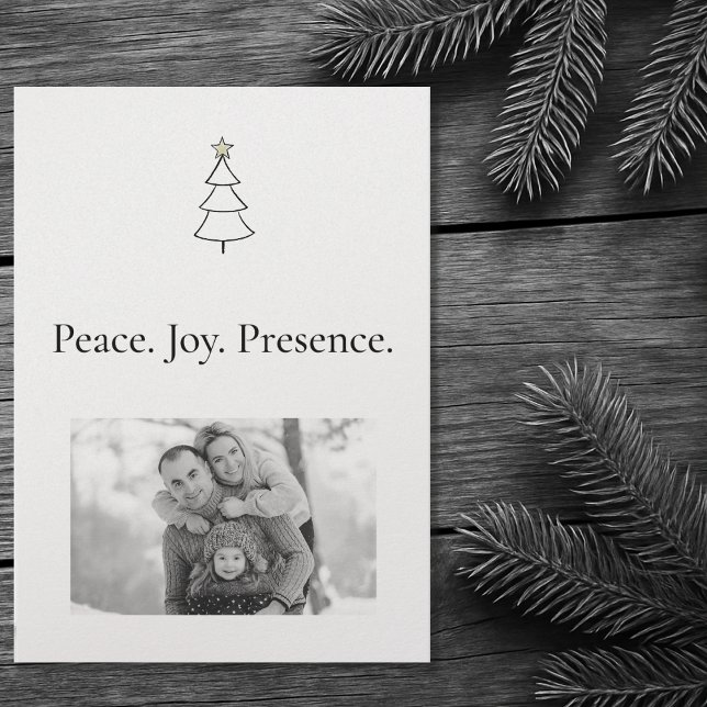 Fred. Joy. Närvaro. Minimalistisk fotojul Julkort (Front of the Christmas card on a wooden table with Christmas pine tree branches.)