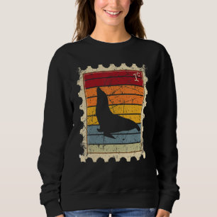 Frimärke med en solnedgångssäl i hamn t shirt