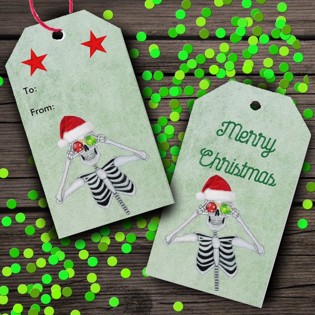 Funny Skeleton Ornament Ögon Red Stars Grönt Presentetikett (Silly Skeleton ornament eyes Santa Hat red stars on green hanging Christmas gift tags.)