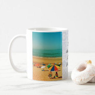 Gamla par under strandparaply i Fonte da Telha. Kaffemugg