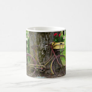 Gammal antik cykel med blommabasketen kaffemugg