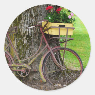 Gammal antik cykel med blommabasketen runt klistermärke