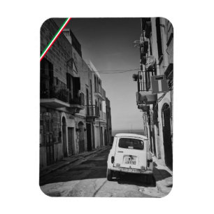 Gammal bil på en gata i Italien med hav Magnet