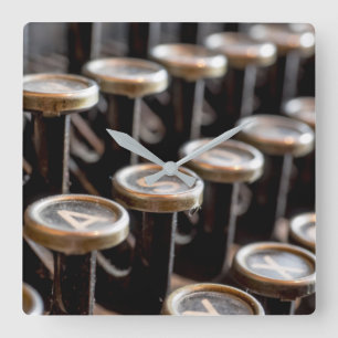 Gammala skrivmaskinsnycklar kvadrerar väggen tar fyrkantig klocka