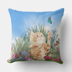 Ginger kitten leker med fjäril utomhuskudde