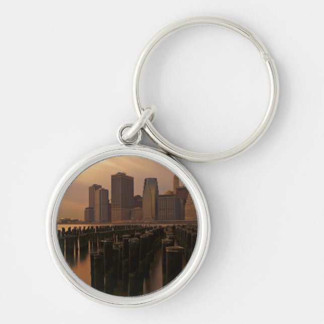 Glöd av solnedgången under stormiga himmlar över rund silverfärgad nyckelring (Framsidan)