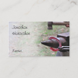 Glödhet hästsko på ett städ visitkort