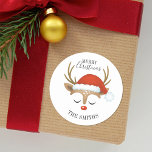 God jul Cute Reindeer Classic Round Sticke Runt Klistermärke<br><div class="desc">En söt renare ansikte med en jultomtehatt dekorerar det med ord God jul. Roligt för att dekorera julklappar och helgdag för att behandla påsar för grannar. Anpassa det med ditt namn. Designad av Blackberry Boulevard.</div>