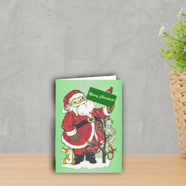 God Jul Tomte Skogs Djur Träd Snö Helgkort (cute Santa with little animals around decorated tree in snow on green Merry Christmas greeting card.)