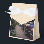 Golden Hour Cityscape Favor Box – Anpassningsbar Presentaskar<br><div class="desc">Denna presentförpackning är inte bara en förpackning – det är ett långsamt, genomtänkt utandningsluft som fångas i kartong och band. Designad av Sotnichenko, bilden på lådan fryser ett ögonblick av mjuk urban stillhet: bilar uppradade i respektfull tystnad, vilda blommor som stryker kanterna, en gyllene himmel som lutar sig mot skymning....</div>