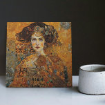 Golden Phase Gustav Klimt Mosaic Edwardian Woman C Kakelplatta<br><div class="desc">Den här vackra keramiska plattan har en grafik som inspirerats av Gustav Klimts "gyllene fas", som skildrar en kvinna från Edwardian-eran. Under denna period fascinerades Klimt av bysantinska mosaiker och utvecklade sin mosaikteknik med hjälp av guld löv och vibrant färg. Denna teckning betalar ett erkännande för Klimts innovativa mosaikstrategi och...</div>