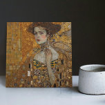 Golden Phase Gustav Klimt Mosaic Edwardian Woman C Kakelplatta<br><div class="desc">Den här vackra keramiska plattan har en grafik som inspirerats av Gustav Klimts "gyllene fas", som skildrar en kvinna från Edwardian-eran. Under denna period fascinerades Klimt av bysantinska mosaiker och utvecklade sin mosaikteknik med hjälp av guld löv och vibrant färg. Denna teckning betalar ett erkännande för Klimts innovativa mosaikstrategi och...</div>
