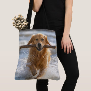 Golden Retriever springer med en strandpinne Tygkasse