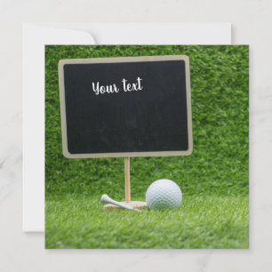 Golf boll med blankchalkboard på grönt gräs