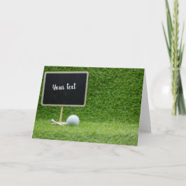 Golf boll med blankchalkboard på grönt gräs kort