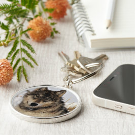 Grå varg eller timmervarg som lägger i snön rund silverfärgad nyckelring