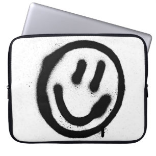 Graffiti leende ansikte-emoticon i svart på whites laptop fodral