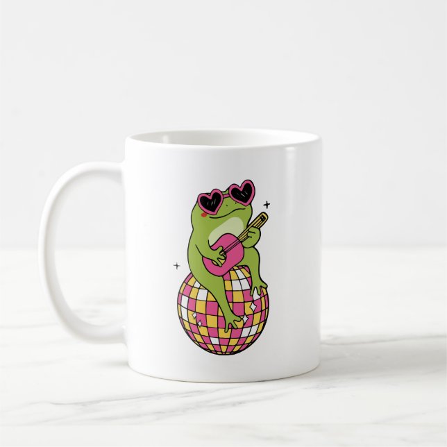 Groda som sitter på dansboll och spelar gitarr  kaffemugg (Vänster)