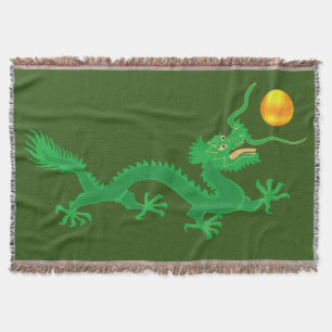 Grön drak med guldsolklot på grön filt