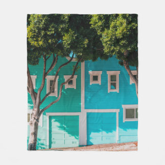 Grönt och blå hus bredvid träd på sidpromenad fleecefilt