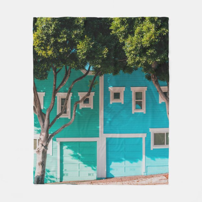 Grönt och blå hus bredvid träd på sidpromenad fleecefilt (Framsidan)