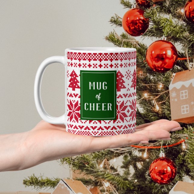 Grönt och Red Sticka Sweater Mugg of jul Cheer (Christmas mug that reads "mug of cheer" with text on a green rectangle over a red and white pattern)
