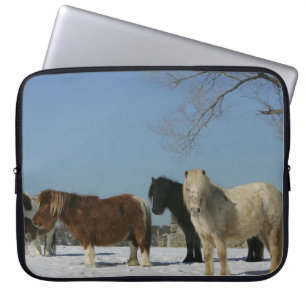 Grupp av miniatyrhästar i snön laptop sleeve