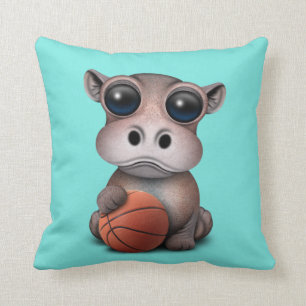 Gullig babyflodhäst som leker med basket kudde