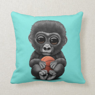 Gullig babygorilla som leker med basket kudde